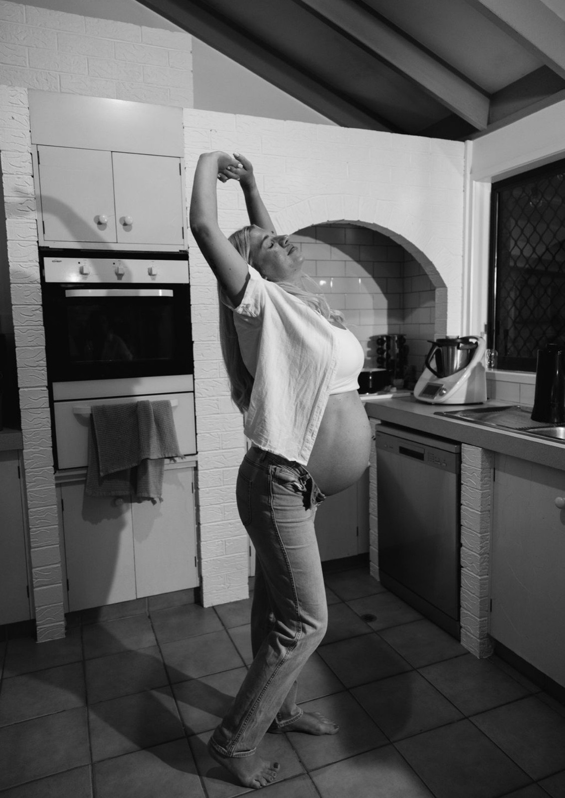 Pregnant woman easing back tension at home